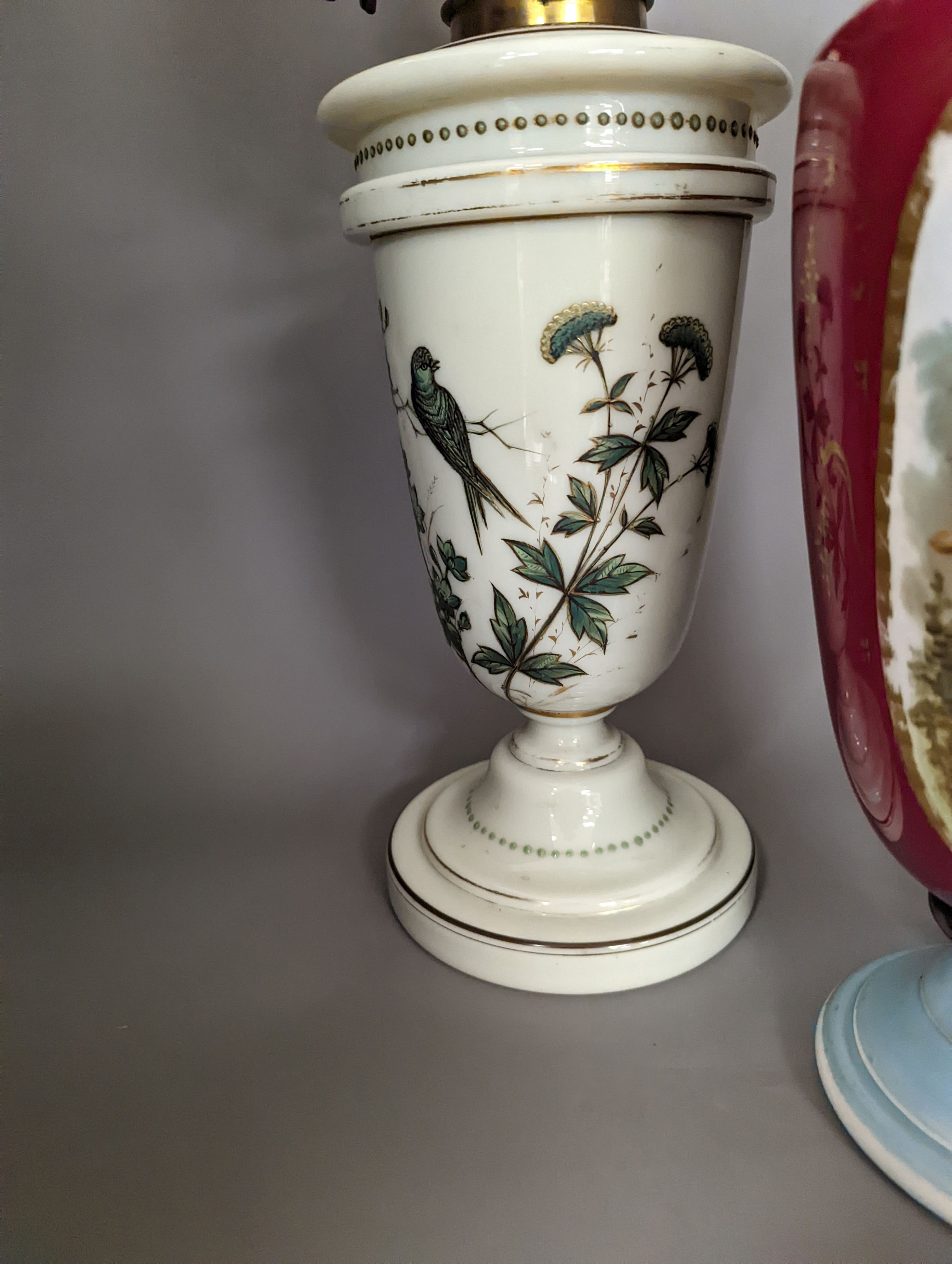 A late 19th century French enamelled green glass oil lamp and glass shade and a Paris porcelain vase, Oil lamp 61 cms high.